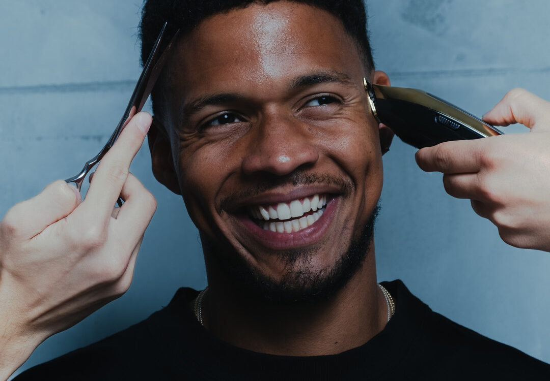 Smiling man getting a haircut at La Familia Barber Shop in Dorćol, Belgrade