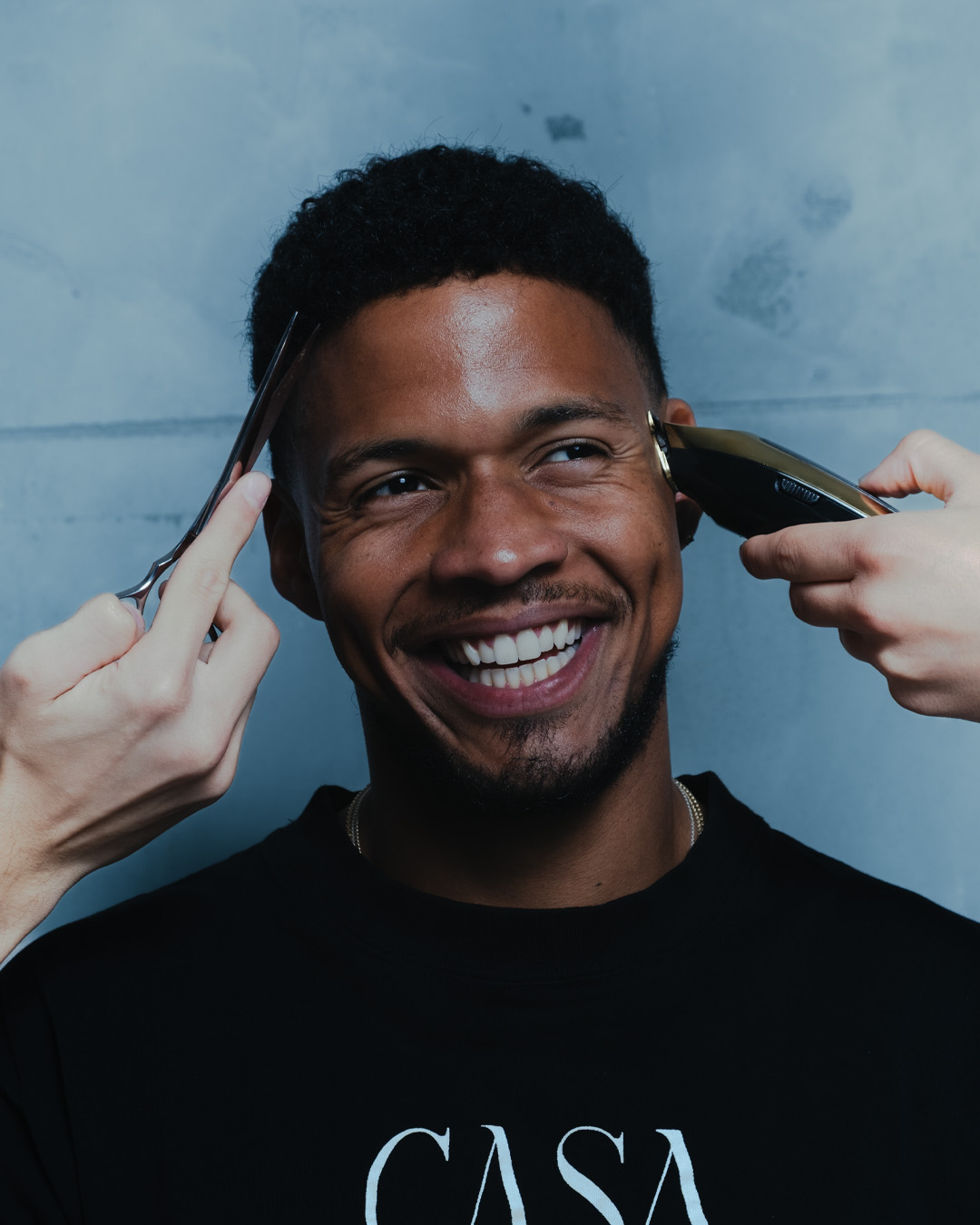Smiling man getting a haircut at La Familia Barber Shop in Dorćol, Belgrade